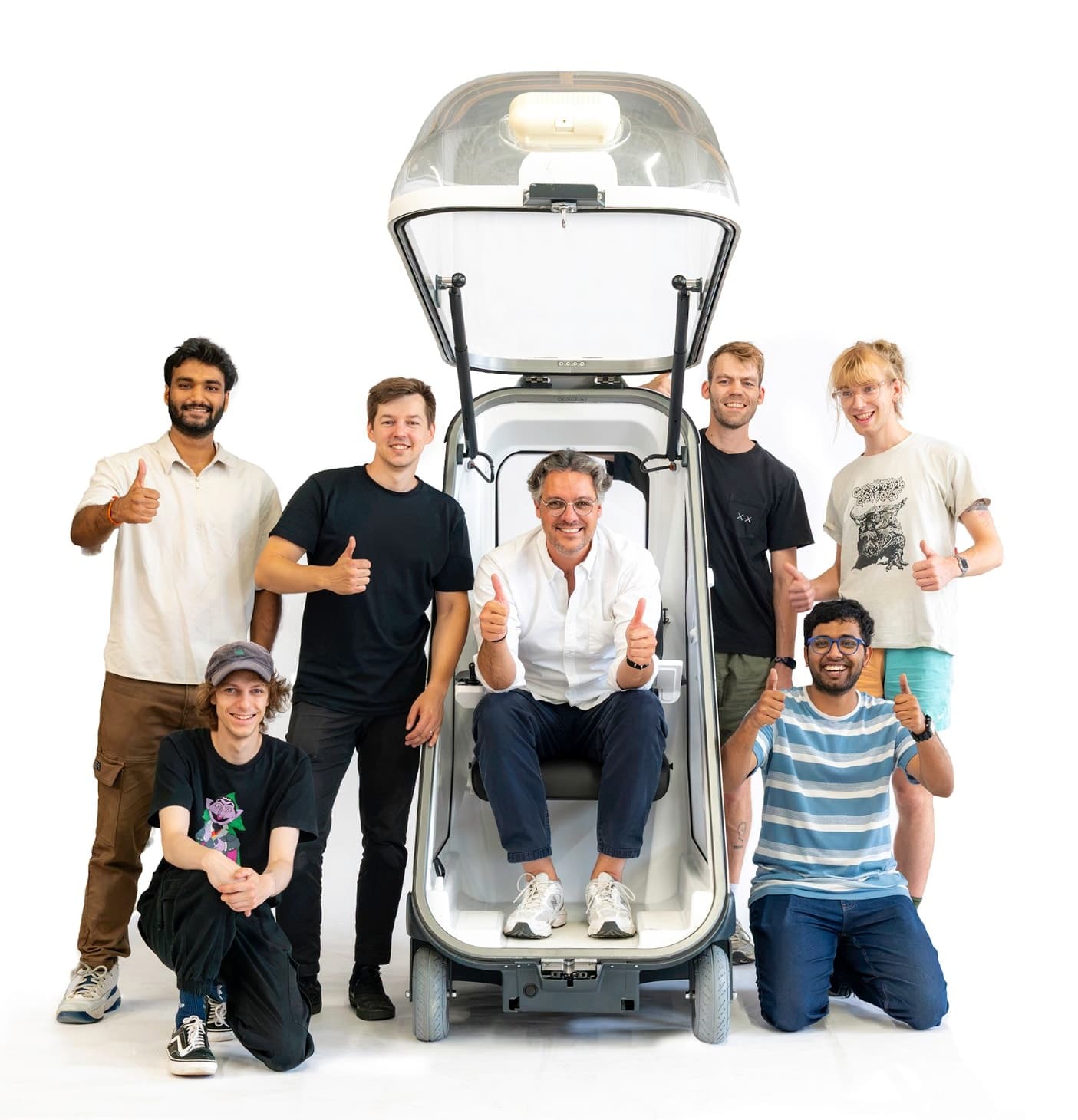 The Sphaira team gathered around MOBY, thumbs up, one of them seated inside with the canopy open
